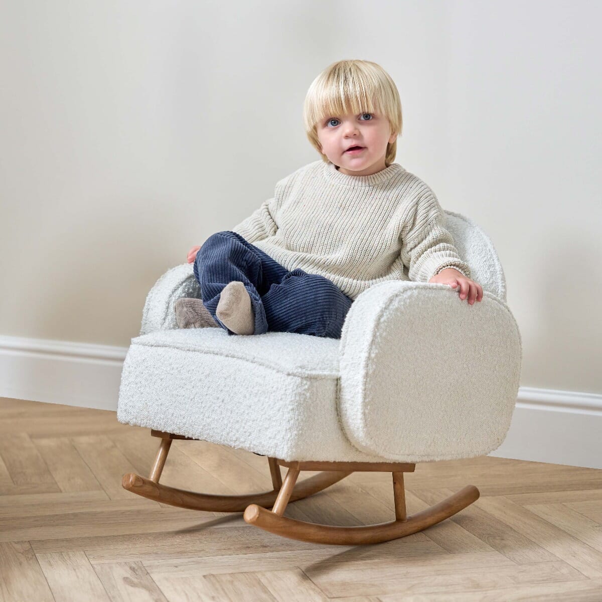 Lifestyle view of child using the Micah Mini Me Rocking Chair in Fresh Cream, demonstrating child-friendly proportions and gentle rocking feature.