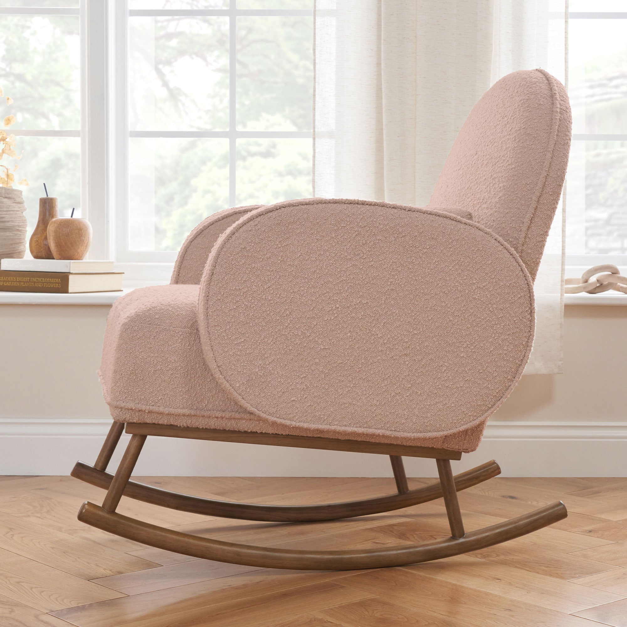 Side view of Micah Rocking Chair in boucle blush set in a bright living space, showing smooth rocking motion base and plush curved backrest for relaxation.