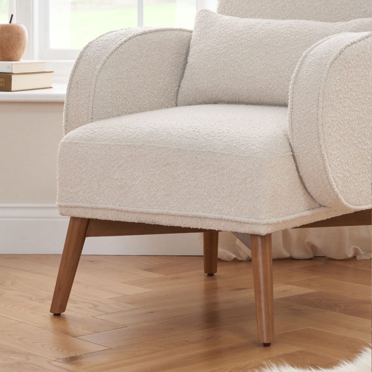 Close-up of the Micah rocking chair in fresh cream, showing plush upholstery, lumbar cushion, and wooden legs on parquet flooring.
