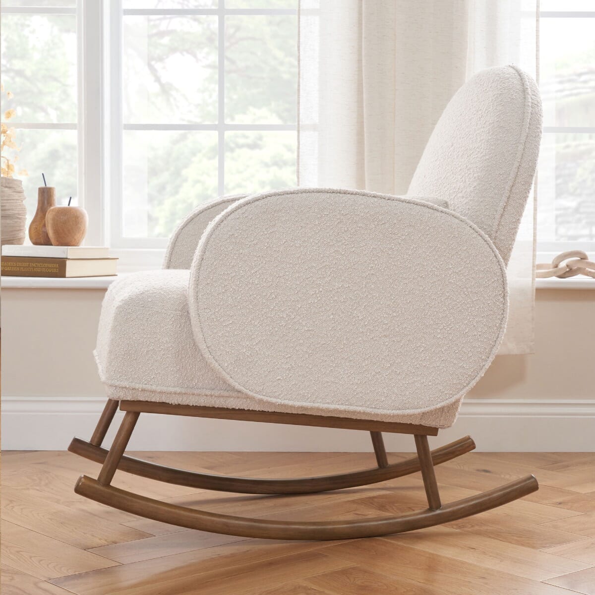 Side view of Micah rocking chair in fresh cream in a lifestyle setting, highlighting its soft texture and wooden curved rocking legs.