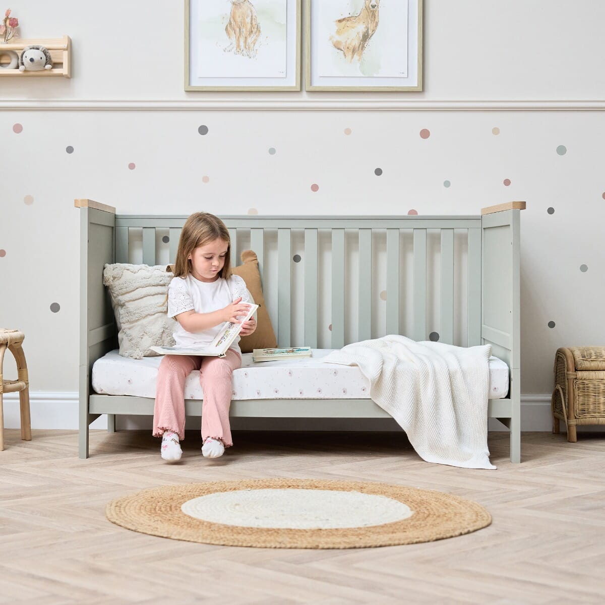 Misha Cot Bed in Sage & Golden Oak - lifestyle image in sofa mode with little girl reading a book