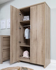 Modena wardrobe in oak finish shown in nursery room with an open door, featuring spacious shelves and hanging rail for practical children's clothing and storage organization.