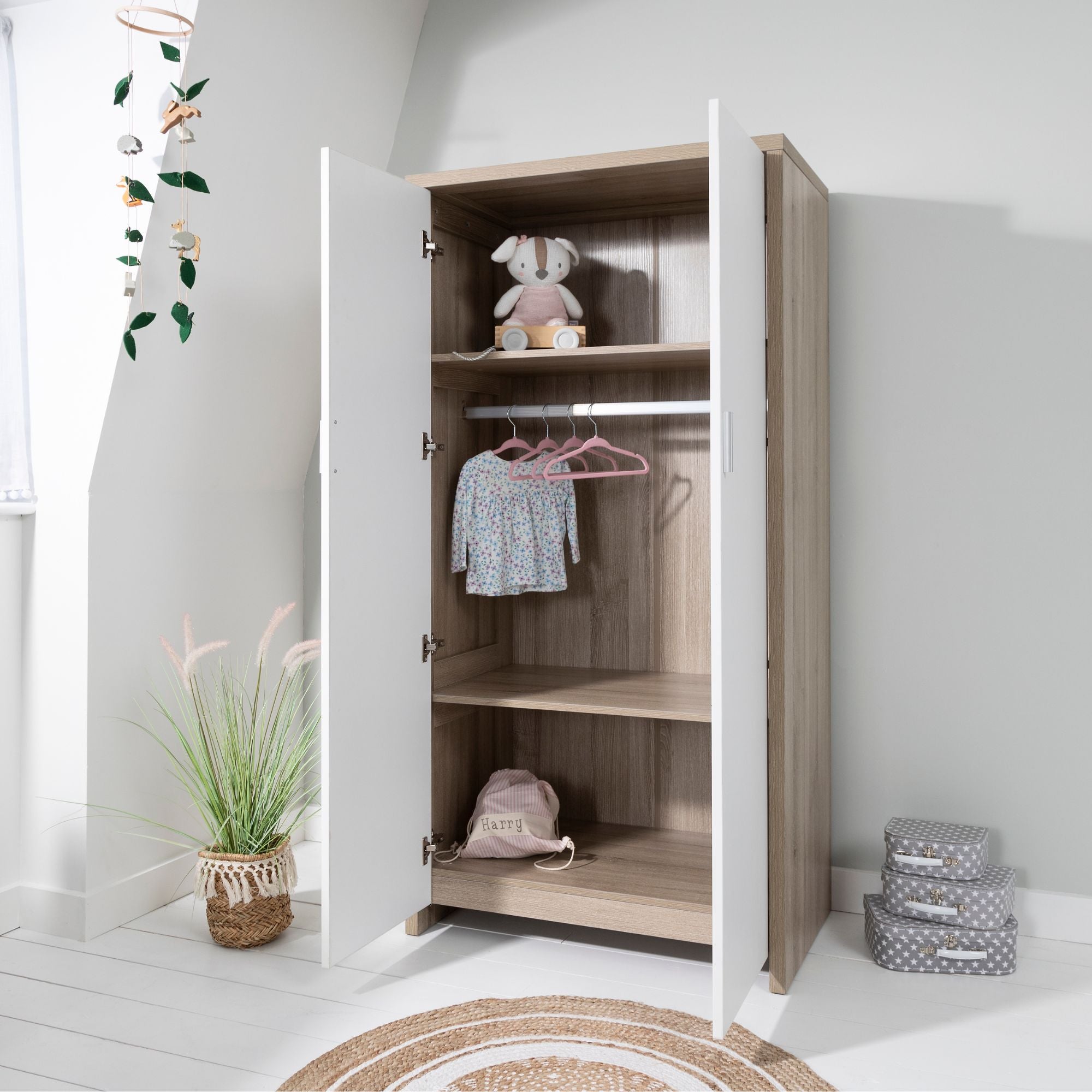 Modena wardrobe in white and oak with white double doors open, showing internal hanging rail, adjustable shelving and spacious storage compartments