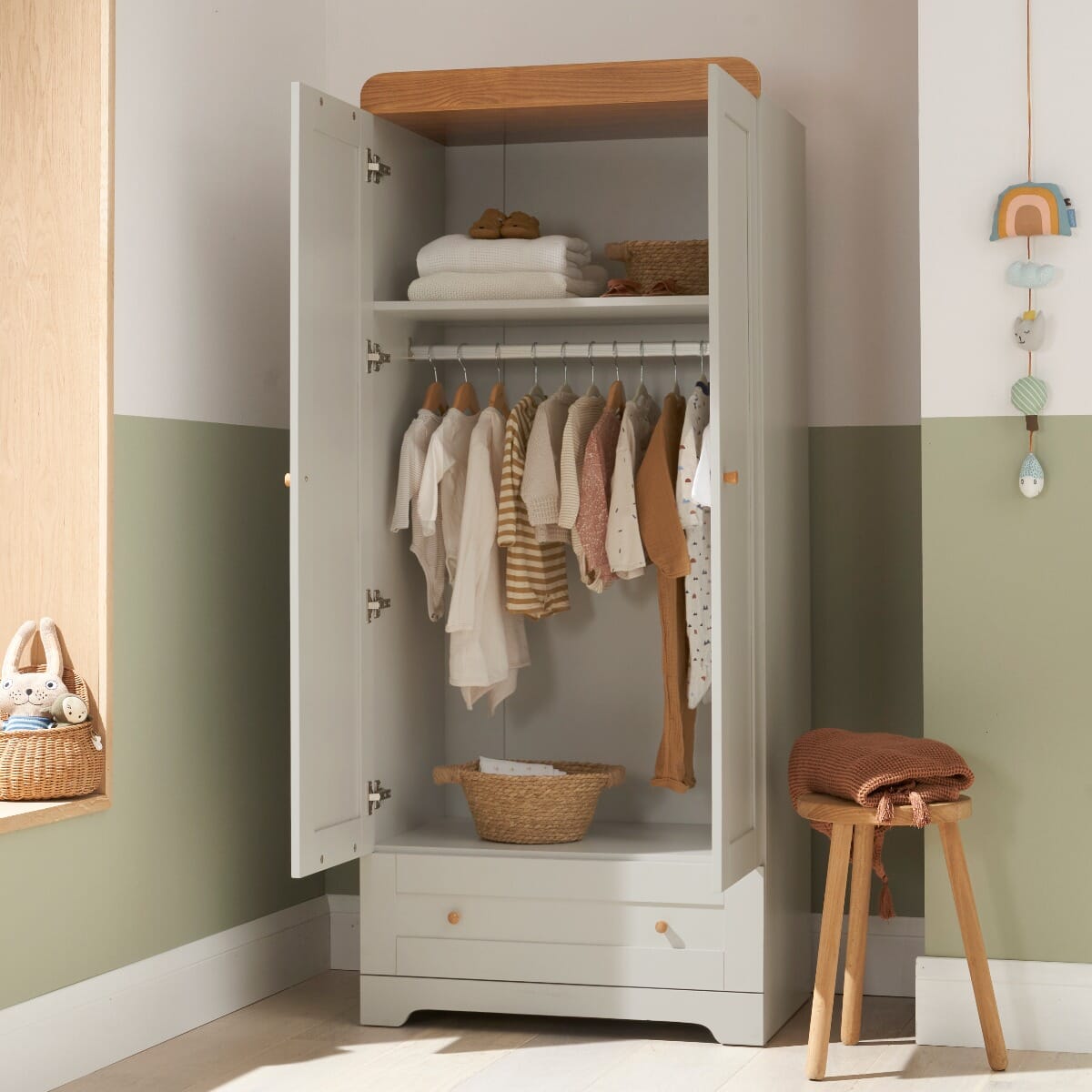 Front view of the Rio wardrobe in Honey Oak and Dove Grey with doors open, showing internal hanging rail, shelf, and bottom drawer for versatile nursery storage.