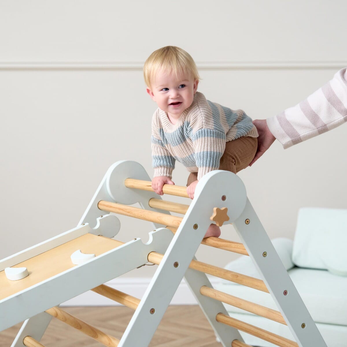 Toddler climbing ladder of the Scala Montessori Pikler in sea mist, promoting independence and motor skill growth in active play