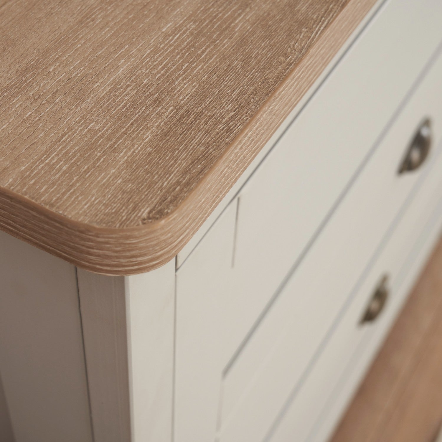 Close-up of Verona chest changer in white and oak – detailed view of the soft rounded corner and textured oak-effect top, highlighting the smooth finish and craftsmanship of the nursery dresser.