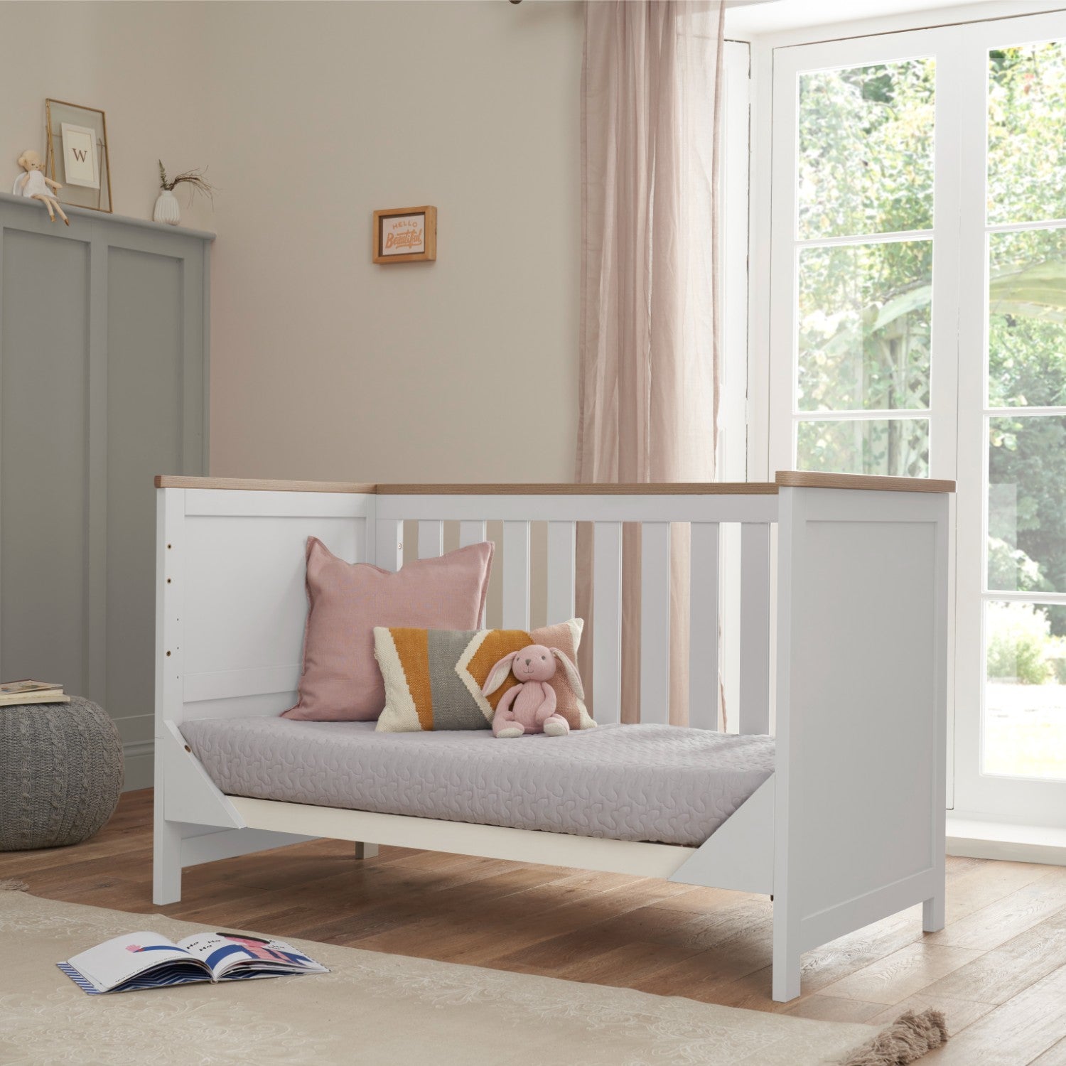 verona cot bed in white and oak converted into sofa bed mode, showing its adaptable functionality for growing children