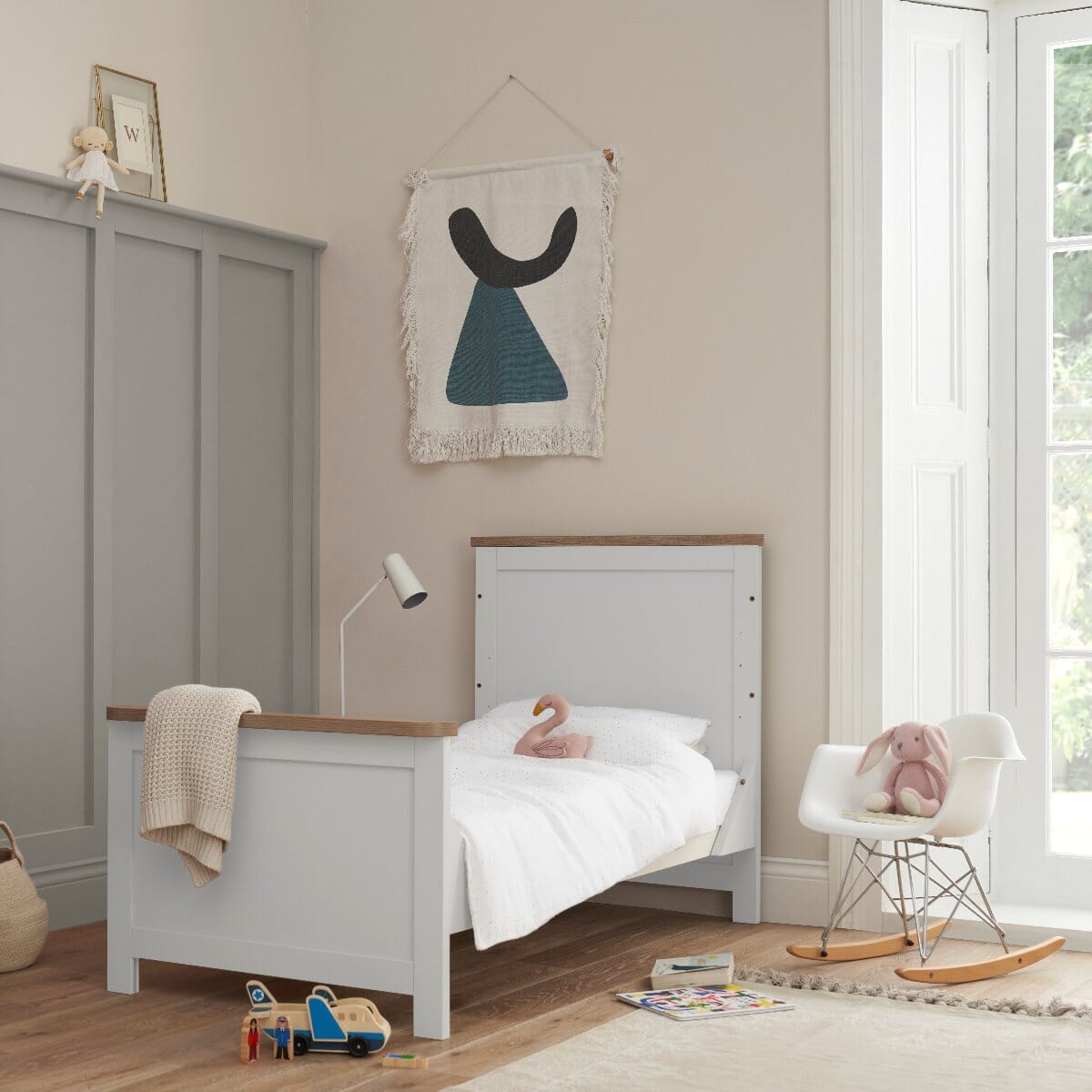 Verona cot bed in white and oak converted to toddler bed mode – supports a smooth transition from cot to first bed
