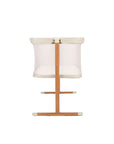 Baby crib with ecru top, mesh panel and wooden legs on a white background