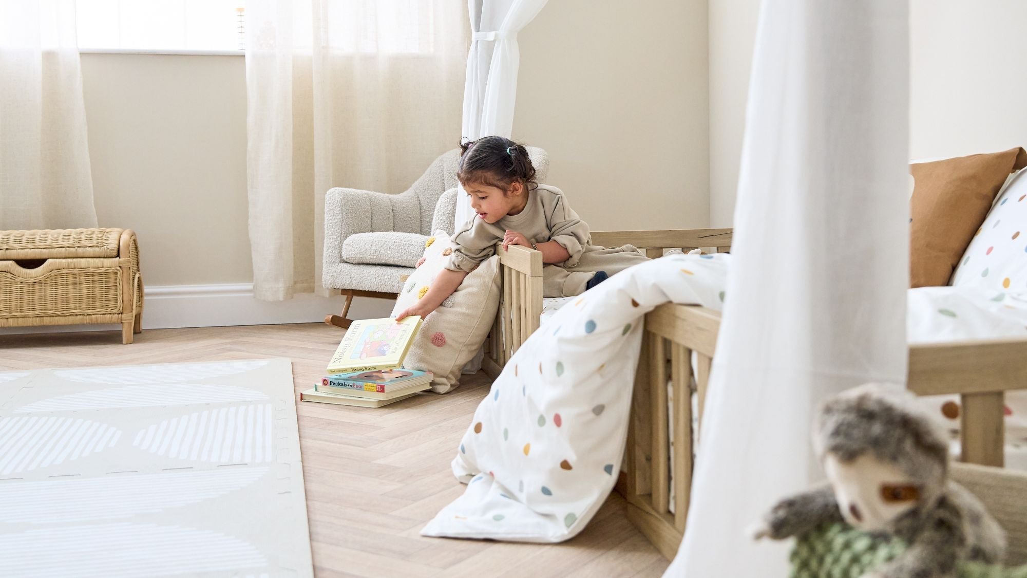 Little girl playing in her Casa Grande Montessori house shaped toddler floor bed. 