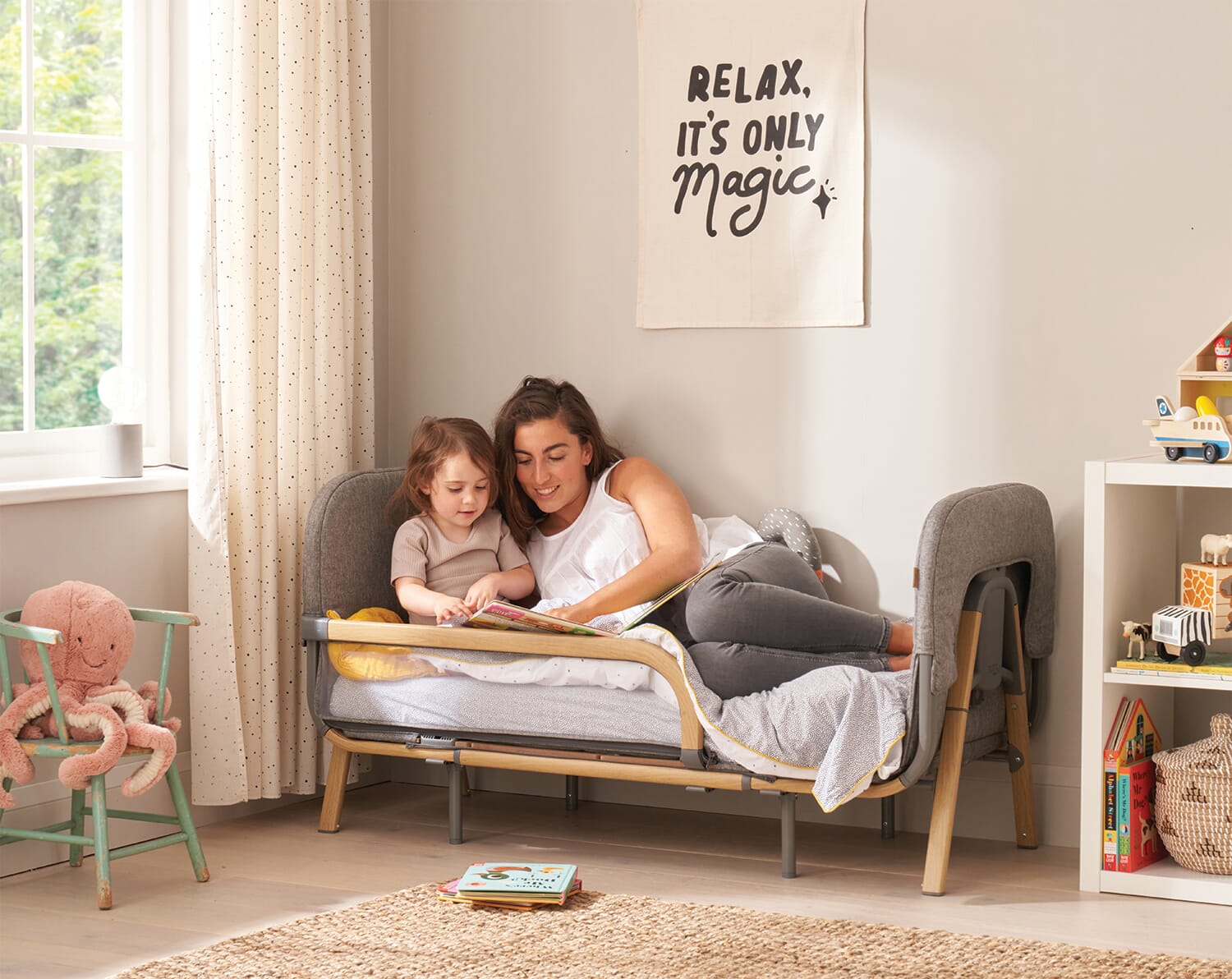mother reading to child on cozee XL converted into toddler bed mode