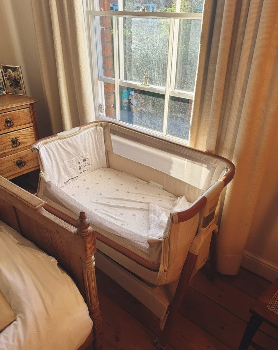 cozee bedside crib shown next to the window with natural sunlit shining through