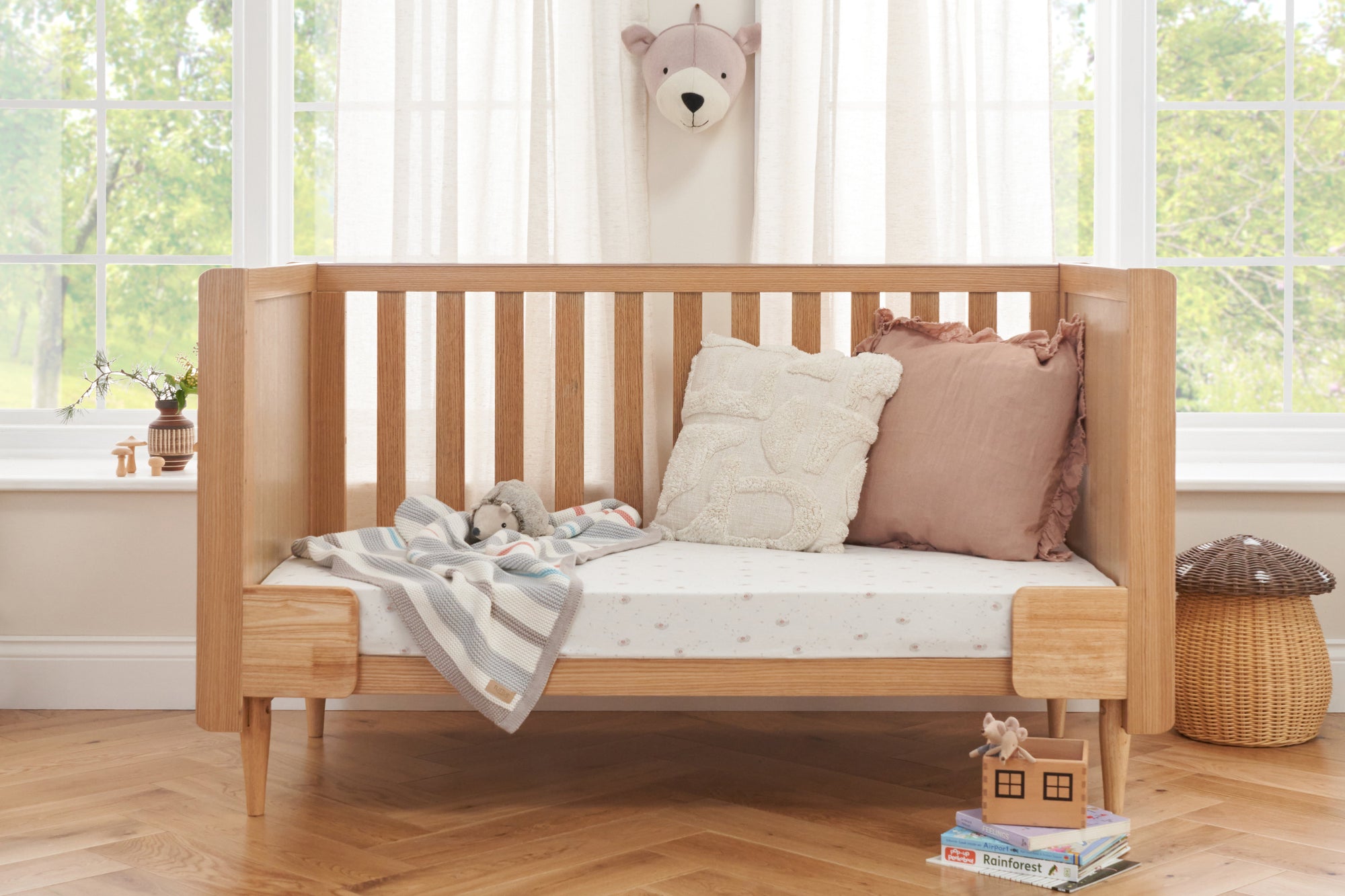 A toddler's bed in an light oak finish.