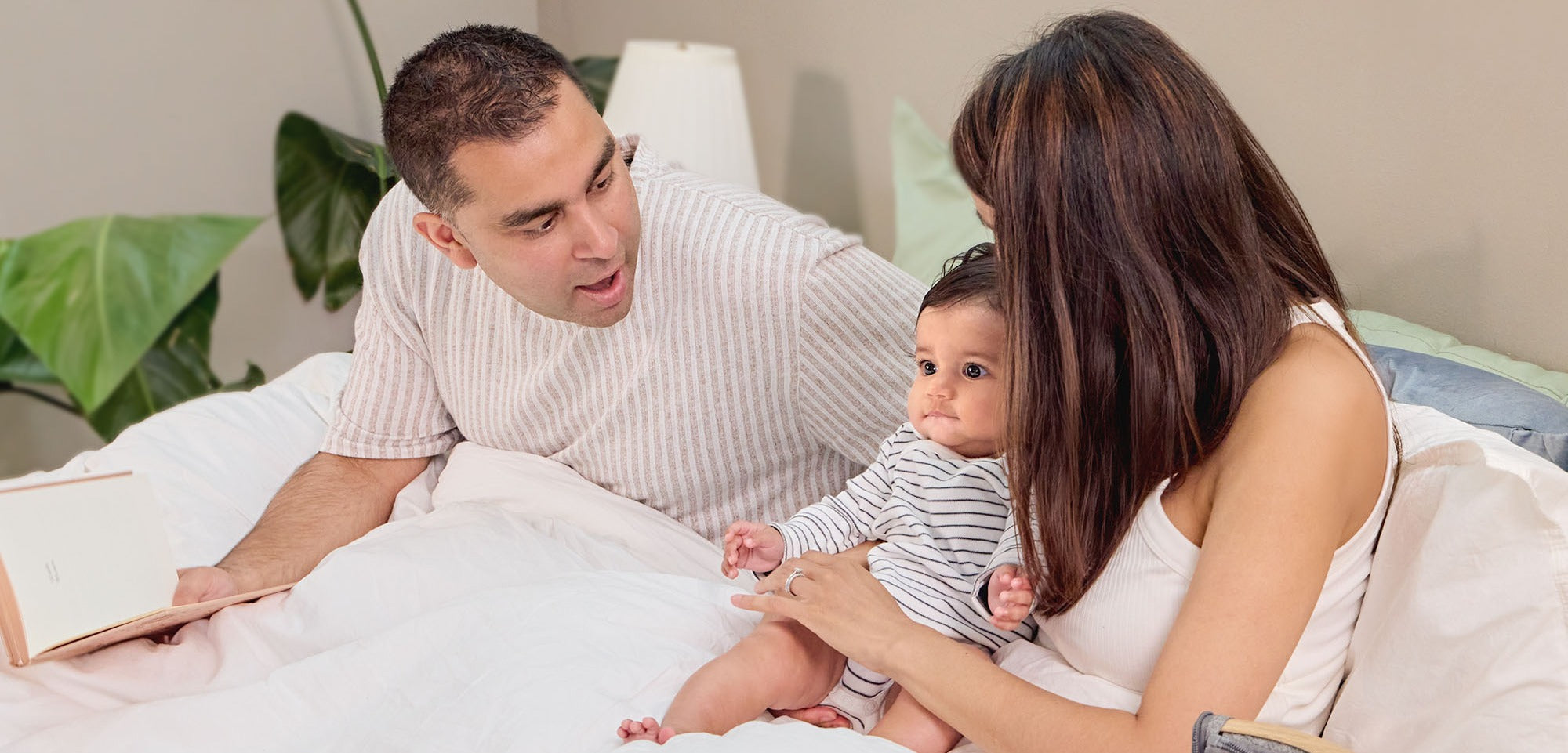 dad, mum and baby rest cosily in their bed