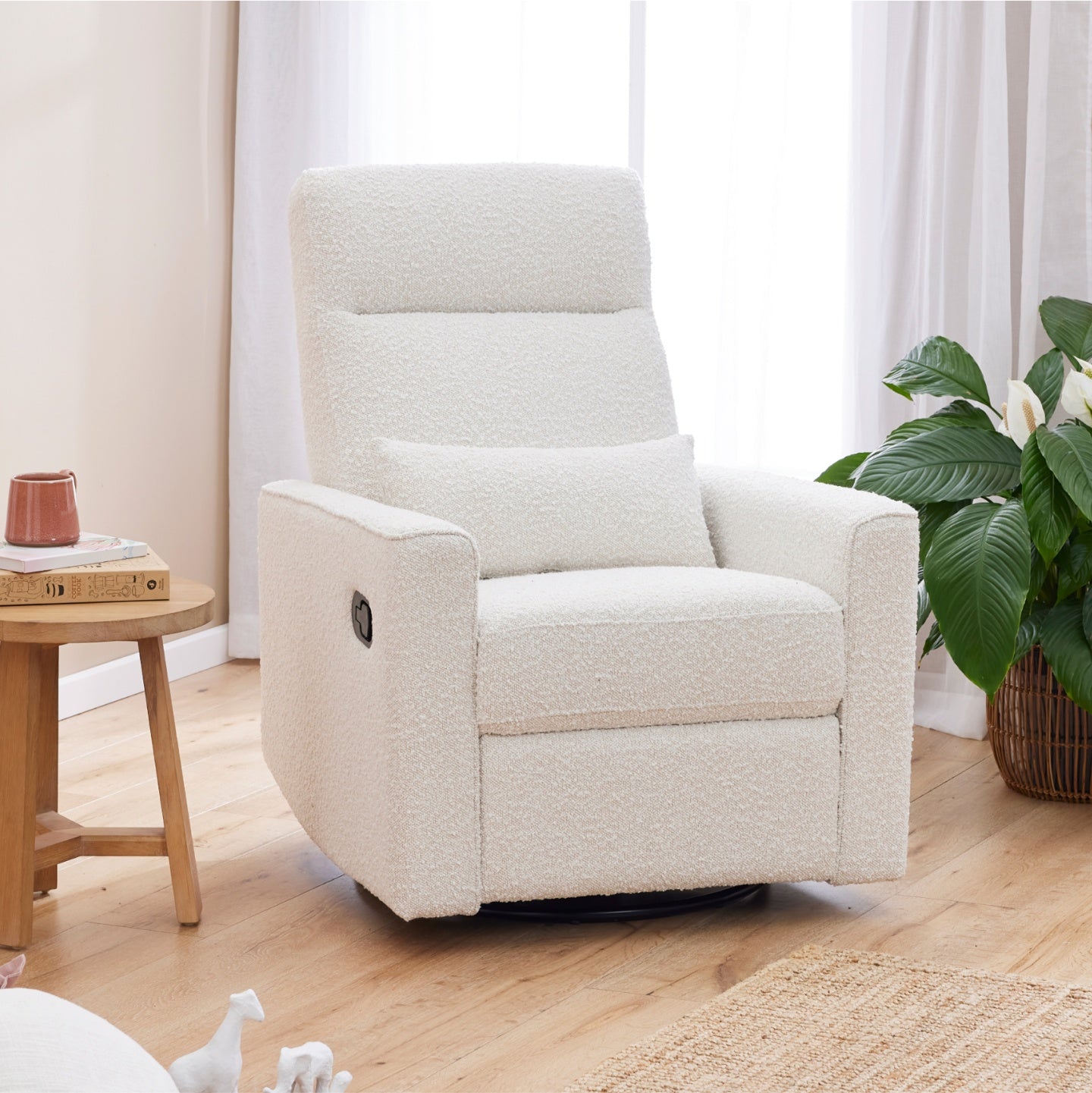 Paige recliner nursery chair in a room with a small table and a plant.