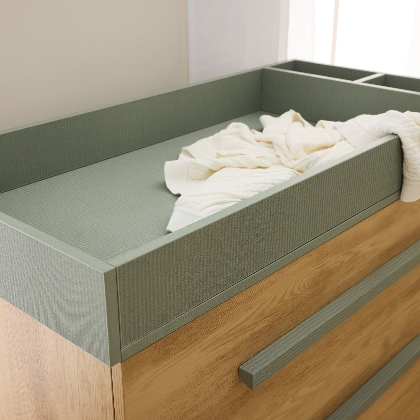 Hallee chest changer in sage weave and golden oak with removable top and divided storage tray.