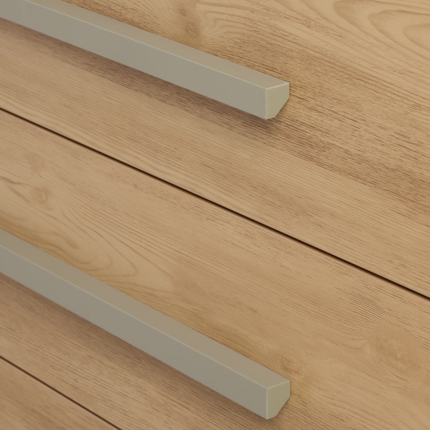 Detail of Hallee chest changer in sage and golden oak highlighting wood grain finish and minimalist sage handles.