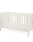 A side view of the Alba cot bed in cashmere in a white background.