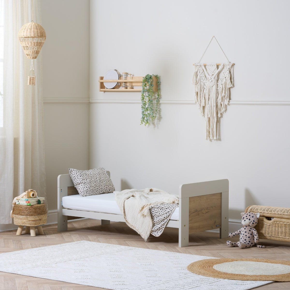 alba mini cot bed in oak white shown in toddler mode in a neutral nursery setting