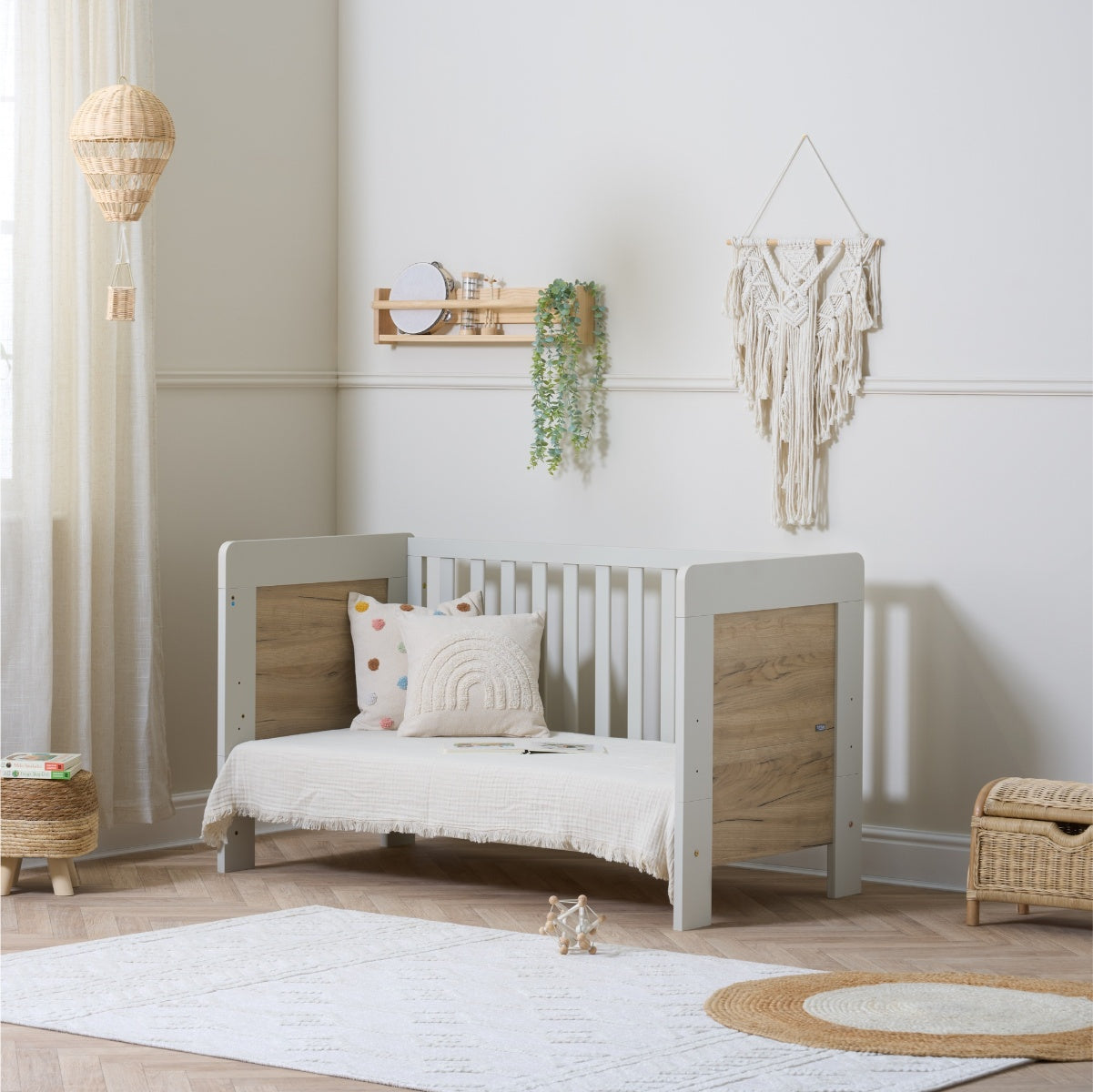 Alba mini cot bed in white and oak in toddler bed mode in a neutral nursery
