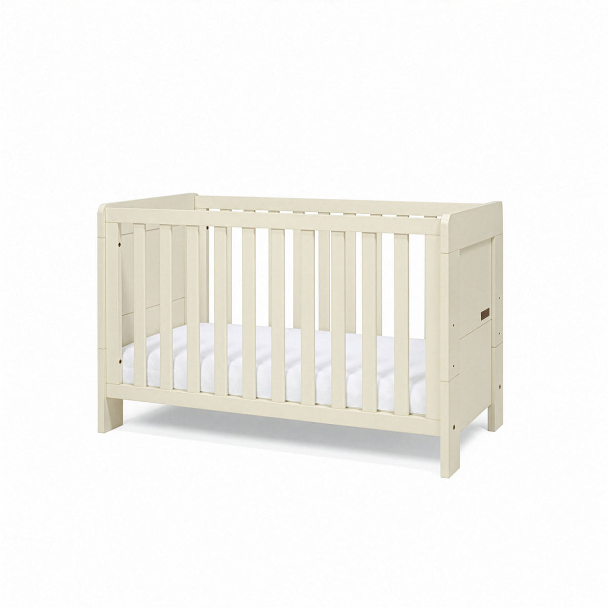 A side view of the Alba mini cot bed in cashmere with a mattress on a white background.