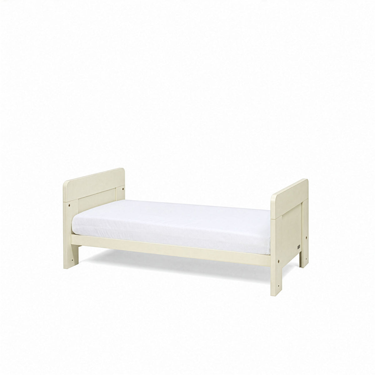 An angle view of the Alba mini cot bed in cashmere converted into a toddler's bed with a mattress on a white background.