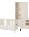 A three-piece nursery furniture set in a cashmere white finish, including a convertible cot bed, a changing table with drawers, and a tall wardrobe with shelves, shown on a solid white background.