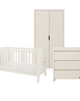 A three-piece baby furniture set in a warm off-white finish, including a convertible cot bed, a tall two-door wardrobe, and a three-drawer changing table, shown on a solid white background.