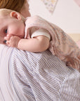 Baby resting on parent’s shoulder in the Tiny Tails sleep bag, gently sucking thumb in a calm and comforting bedtime moment