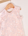 Close-up of Tiny Tails sleep bag on hanger, showing delicate woodland print and popper detail on soft pink breathable fabric