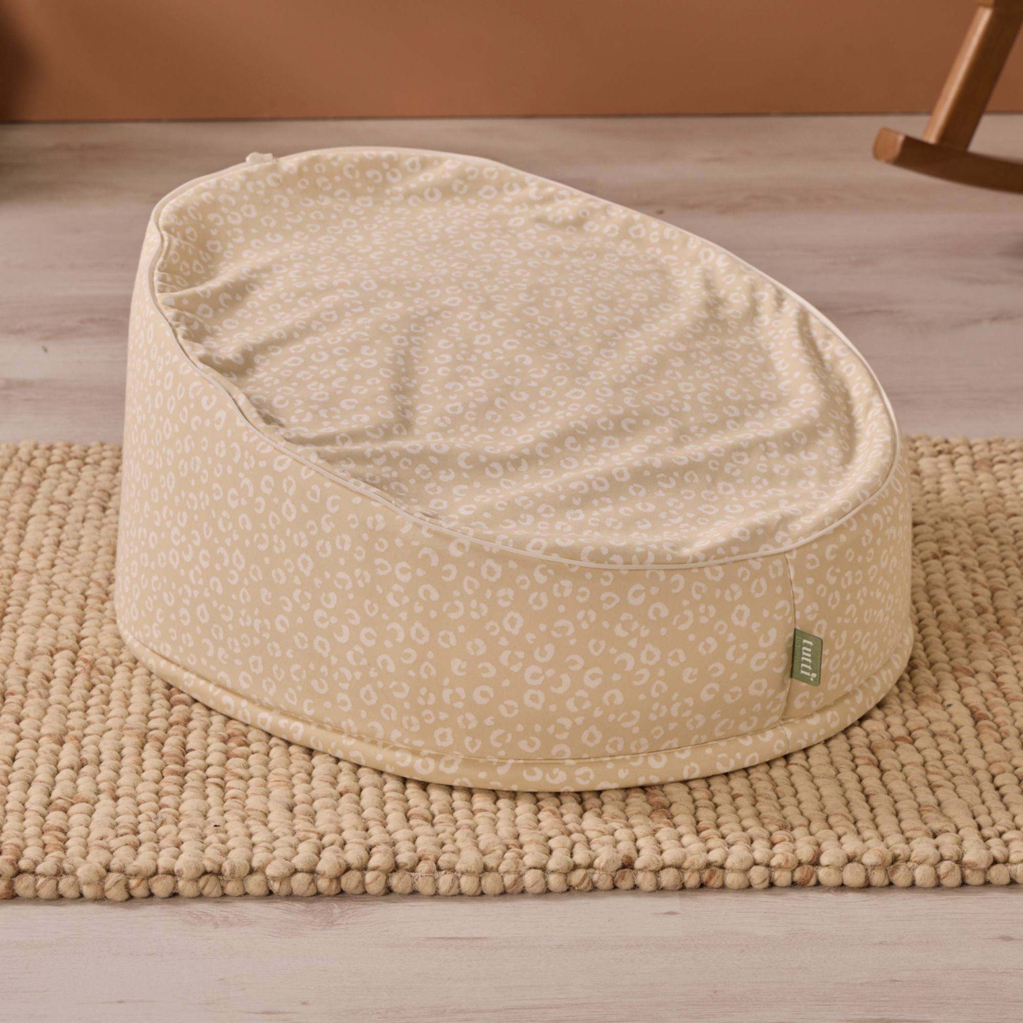 Beige bean bag chair with a subtle pattern on a wooden floor.