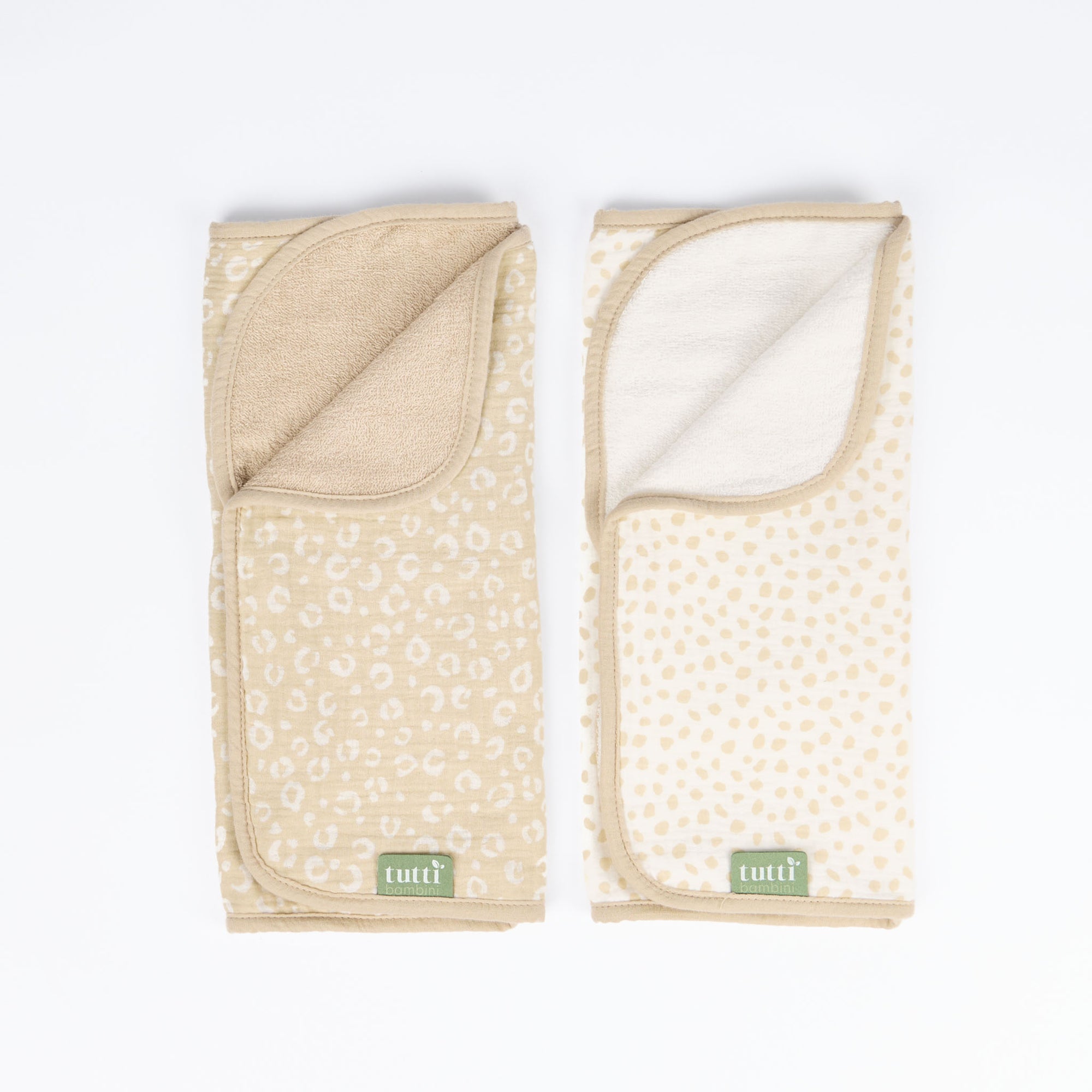 Cutout view of two changing mat liners featuring reversible leopard and spot prints in soft muslin fabric with absorbent towelling back