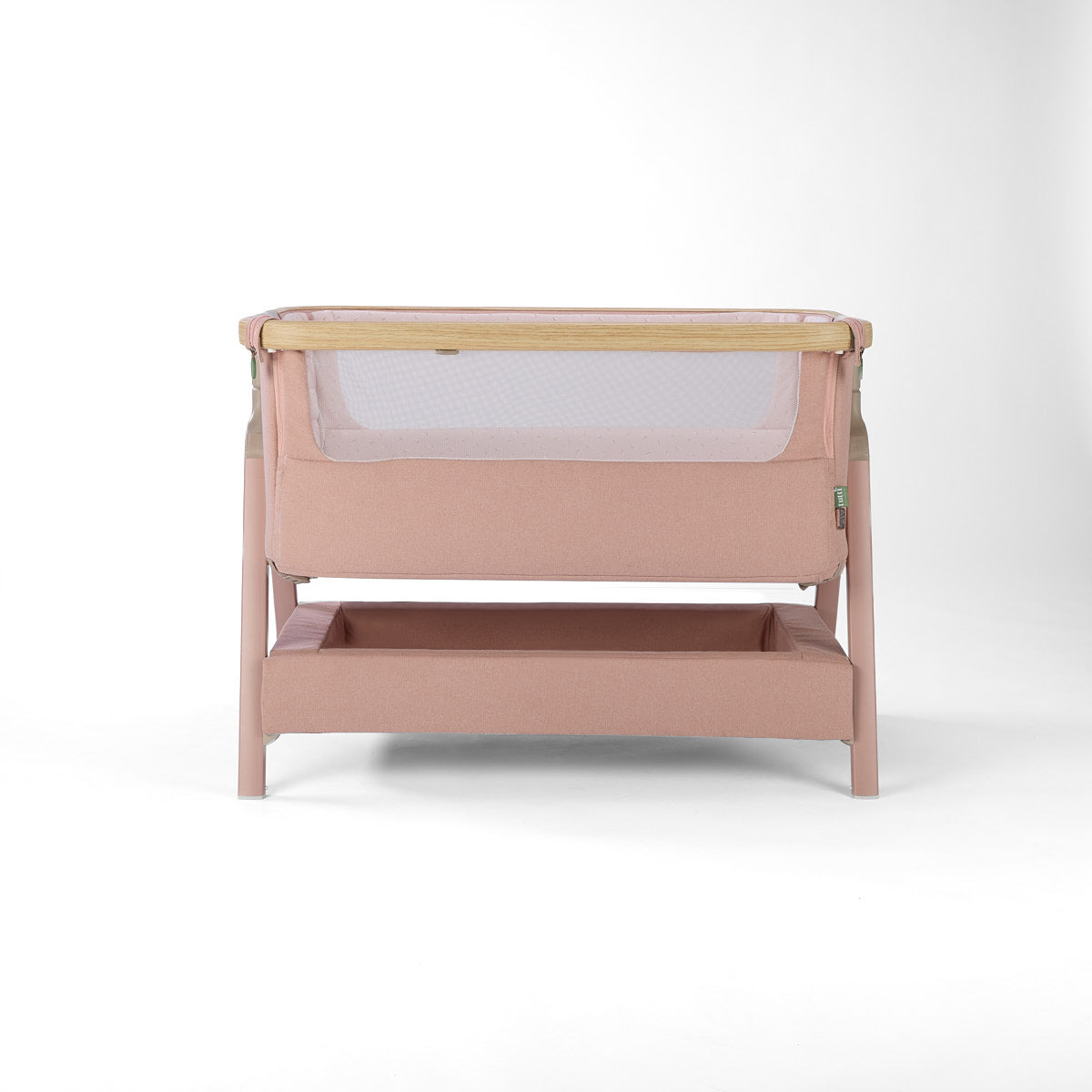 Front cutout view of the CoZee Air 2 bedside crib in blush, showing breathable mesh panel, wooden trim and integrated storage shelf.