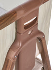 Angle view of the CoZee Air 2 bedside crib in rich walnut and cashmere vintage stripe showing numbered height adjustment settings for bedside alignment.
