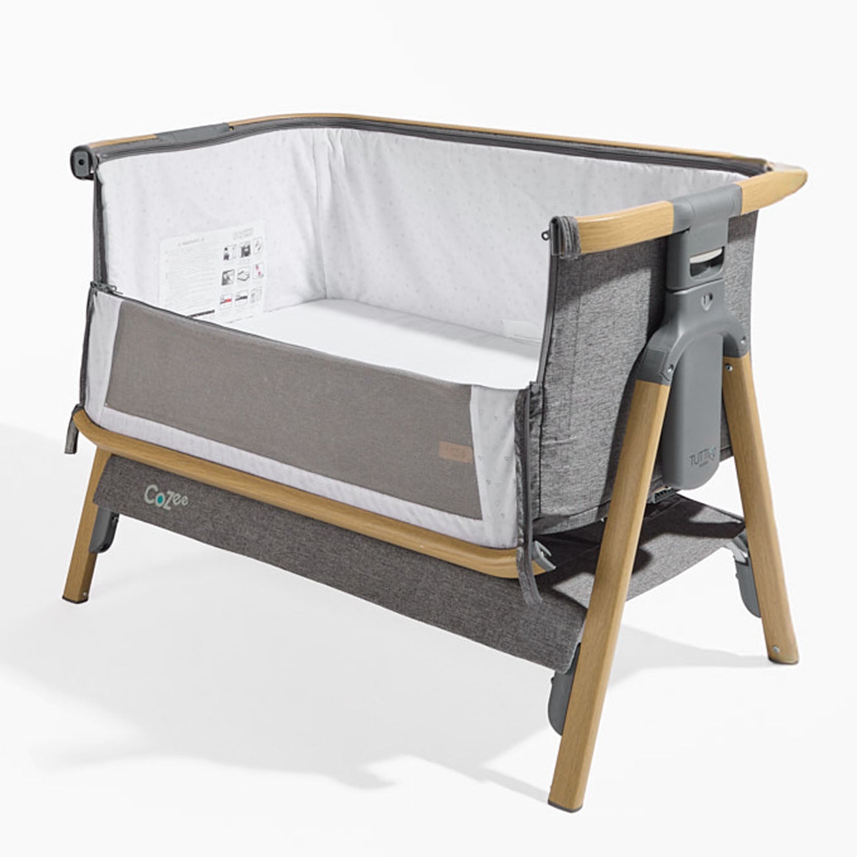 Cutout view of the CoZee bedside crib in charcoal and oak with mesh side panel unzipped, showing breathable liner and wooden frame