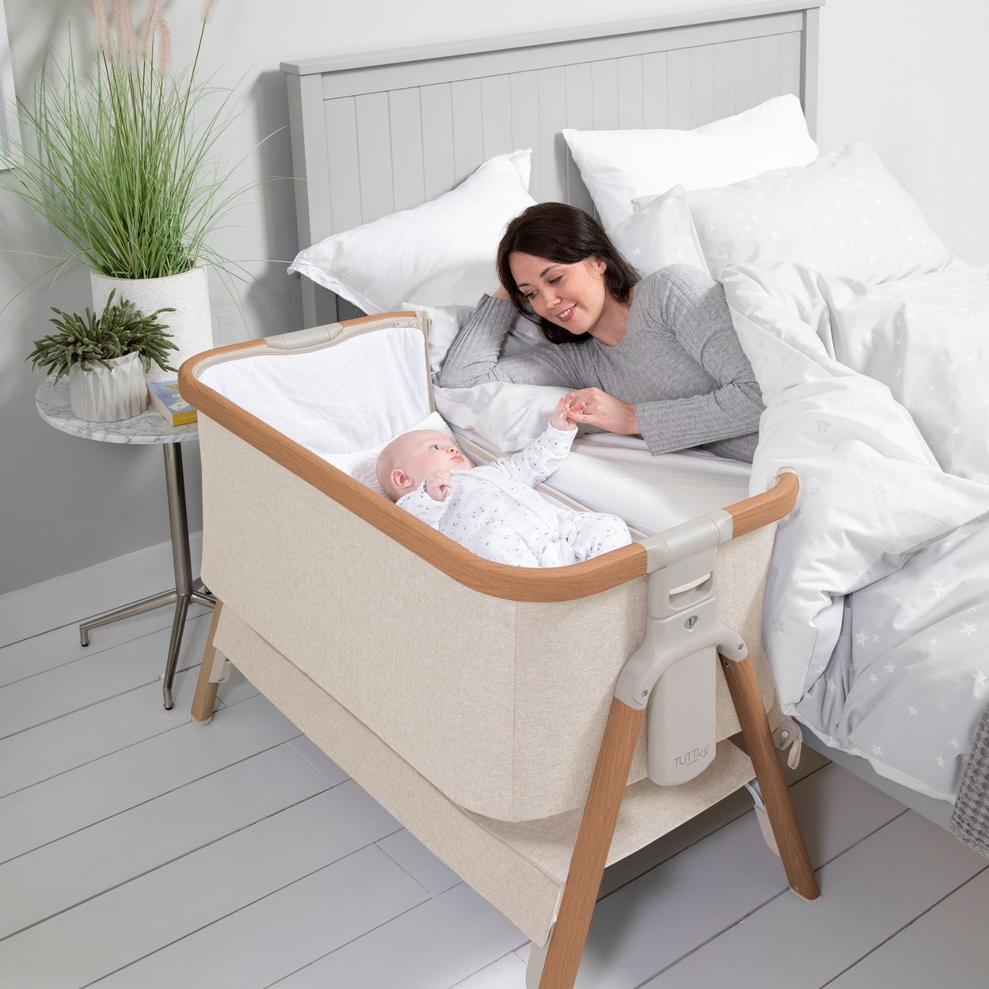 CoZee Bedside Crib in Scandinavian Walnut and Ecru, enabling close bonding with breathable mesh sides.