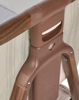 Angle view of the CoZee Air bedside crib in rich walnut and cashmere vintage stripe showing numbered height adjustment settings for bedside alignment.