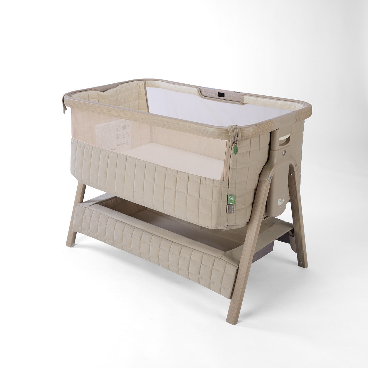 CoZee Sense beige baby crib with mesh and quilted lining sides, storage and sensory bar on a white background