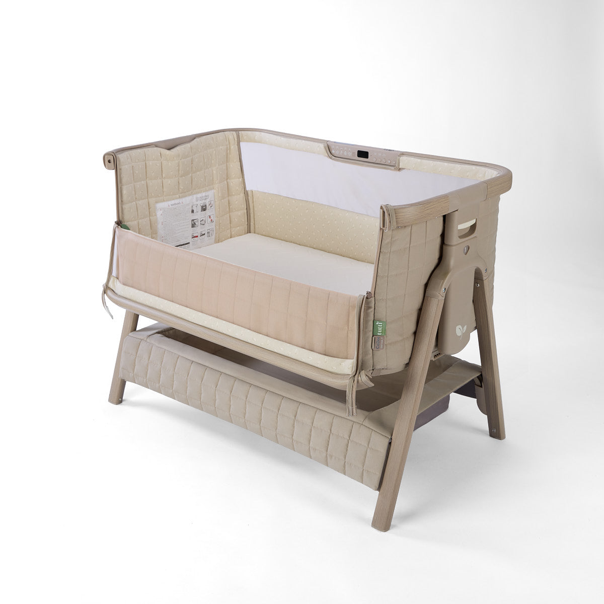 CoZee Sense beige baby crib with mesh and quilted lining sides, storage and sensory bar on a white background