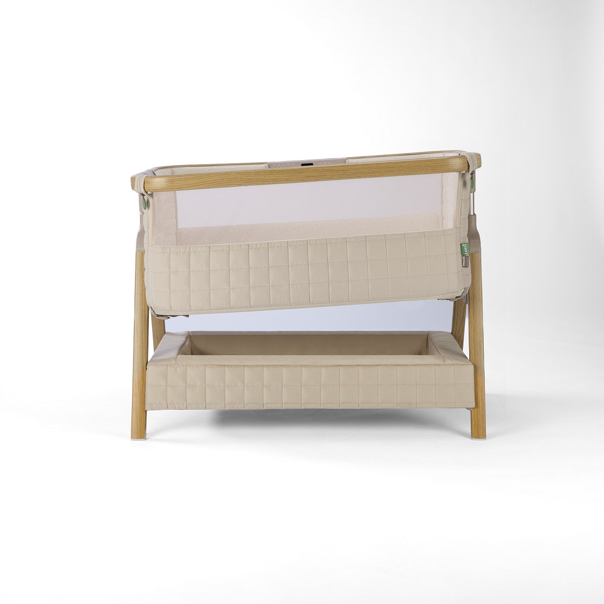 CoZee Sense beige baby crib with mesh and quilted lining sides, incline option storage and sensory bar on a white background