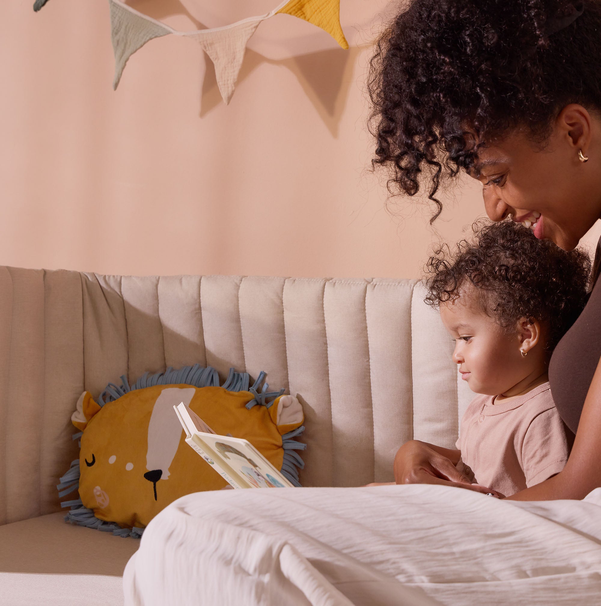 Mum and toddler sit reading together on the CoZee XL in sofa mode, creating a cosy and practical space for bonding