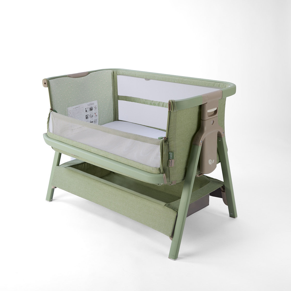 CoZee Zen green baby crib with side open, storage and white mattress on a white background