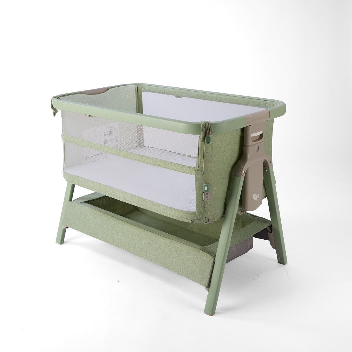 CoZee Zen green baby crib with mesh sides, storage and white mattress on a white background
