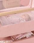 Close-up of the CoZee Air 2 bedside crib in blush, showing breathable mesh sides for improved airflow and clear visibility of baby.
