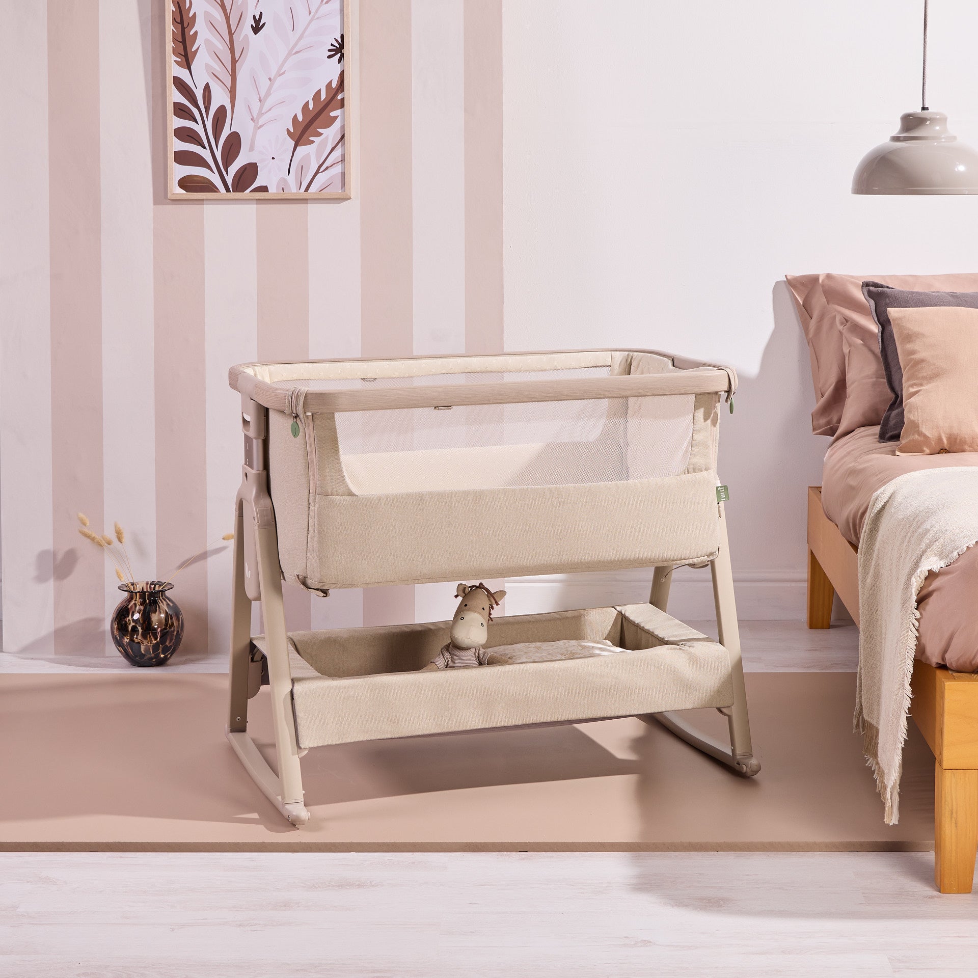 Side view of the CoZee Air 2 in cocoa styled in a bedroom setting, showcasing rocking legs, storage basket and soft neutral design.