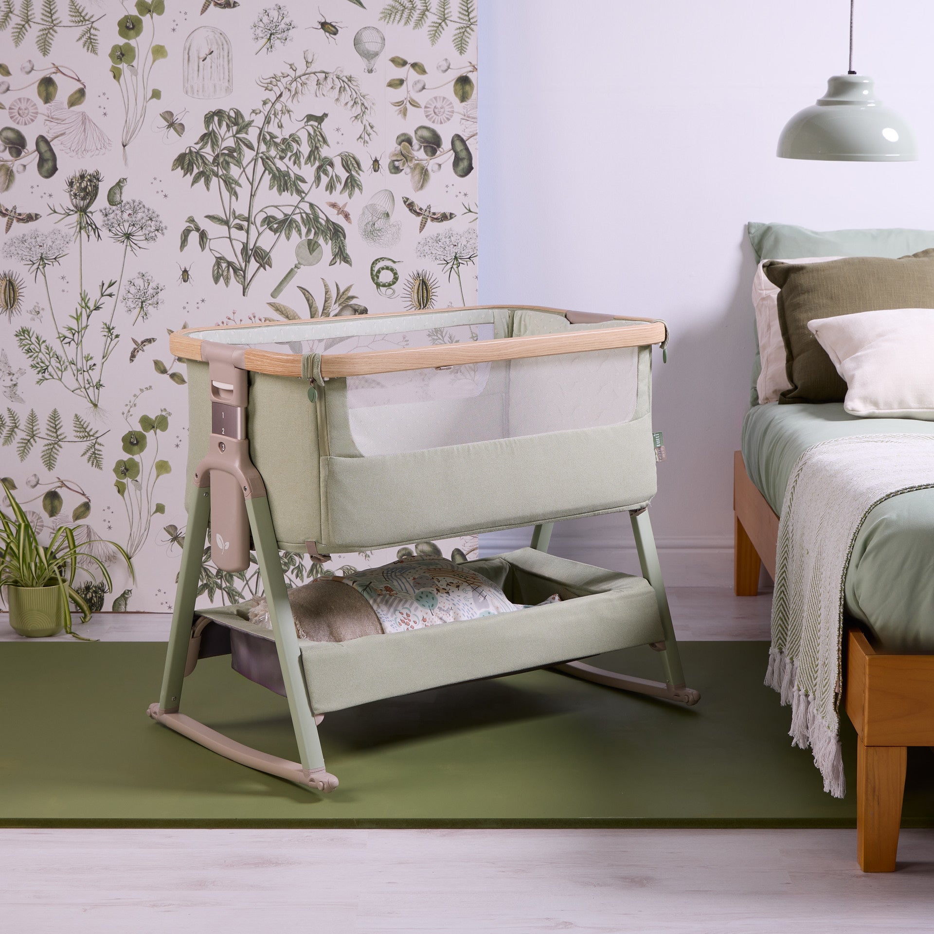Angled view of the CoZee Air 2 bedside crib in eucalyptus, showing breathable mesh sides, wooden-effect frame and calming bedroom styling.