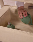 Under-crib storage basket on the CoZee Zen in sand, styled with soft toys for practical everyday storage.