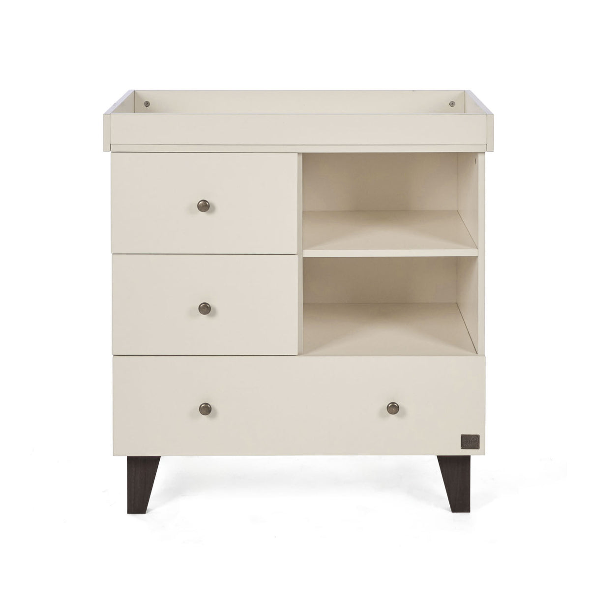 A front view of the Como chest changer in cashmere with a removable changing top, three drawers and open shelving for organised nursery storage.