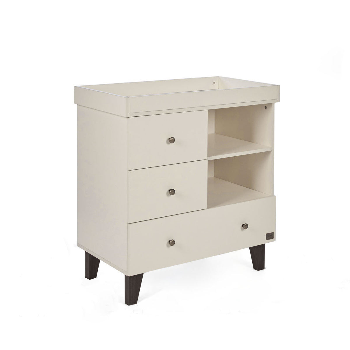 A side view of the Como chest changer in cashmere with a removable changing top, three drawers and open shelving for organised nursery storage.