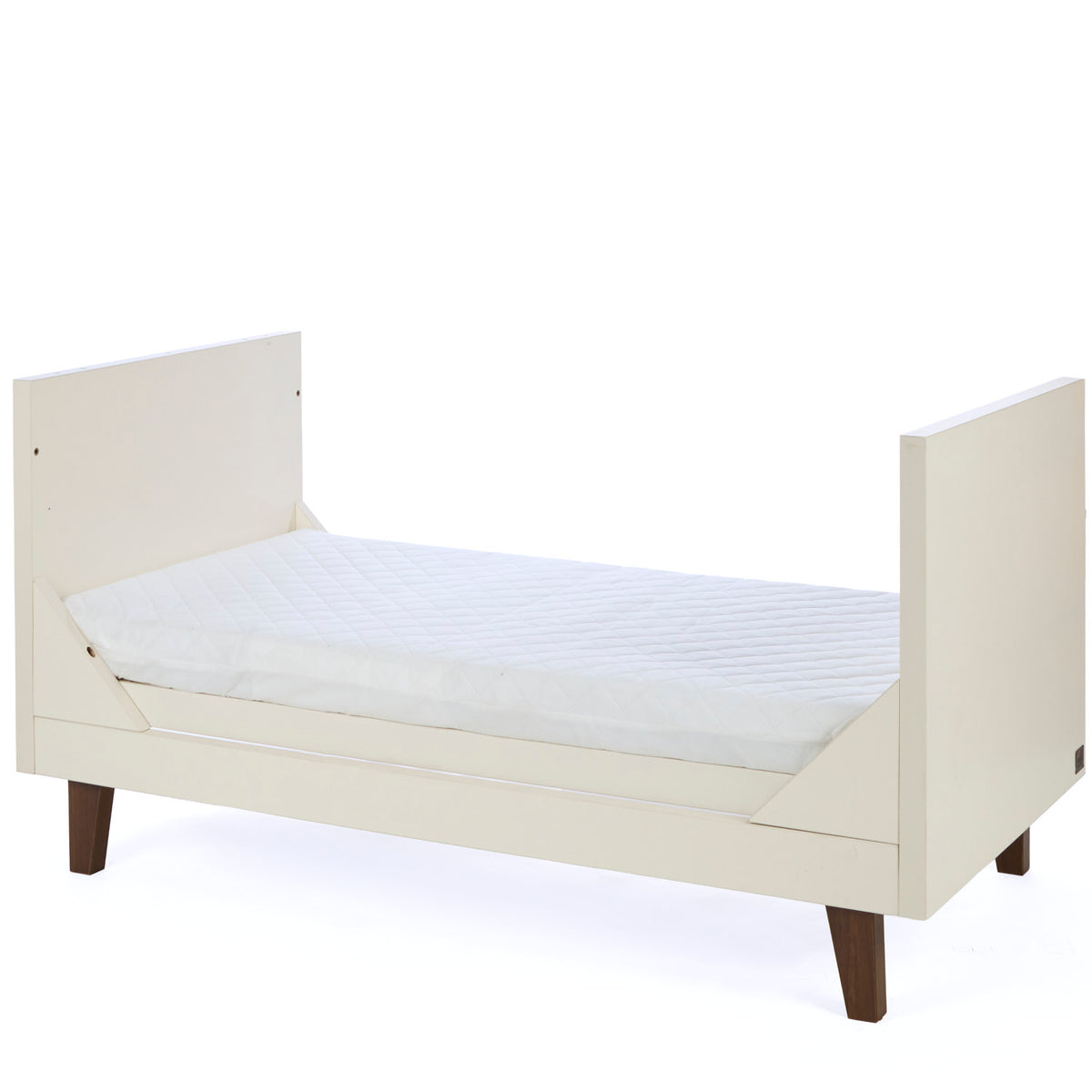 A side view of the Como toddler bed in cashmere and rich walnut, designed with low sides and a modern frame for growing children